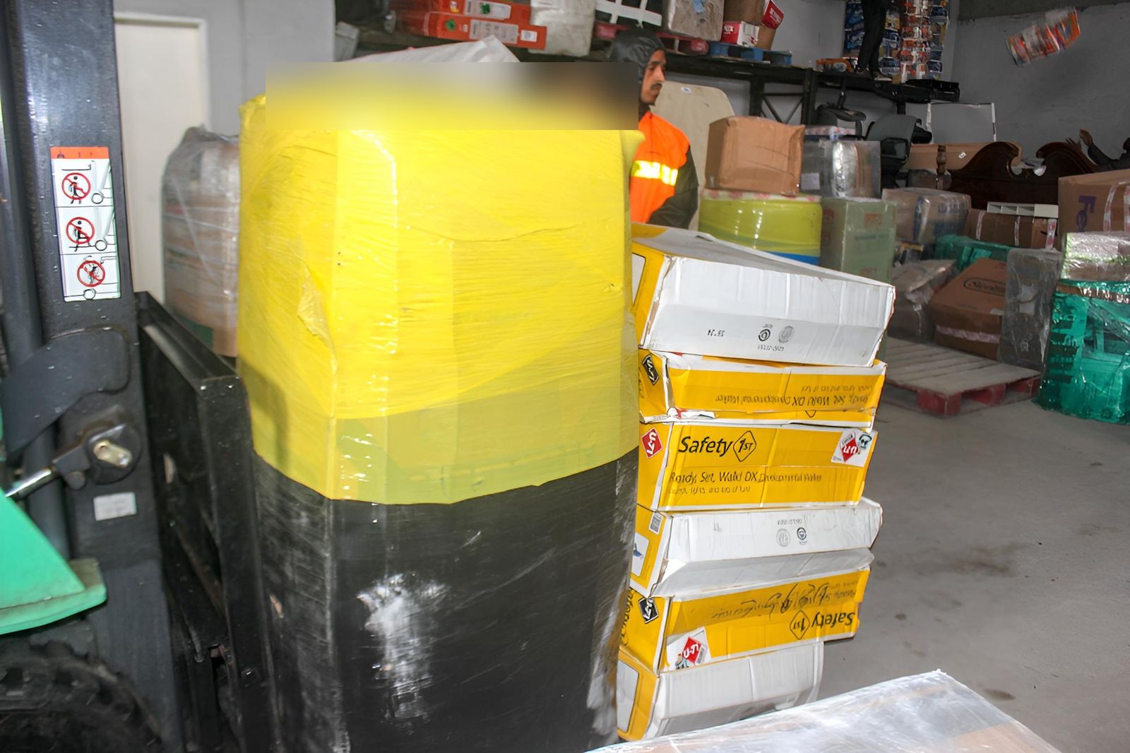 A wrapped barrel and stacked boxes being moved